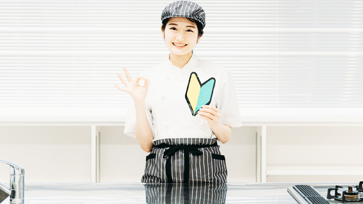 初心者マークを持つエプロン姿の女性